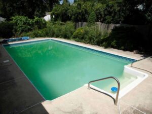 Piscine dont l'eau était verte à cause des algues avant le traitement professionnel