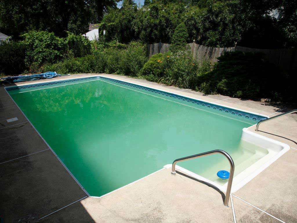Swimming pool with green water caused by algae, prior to professional treatment